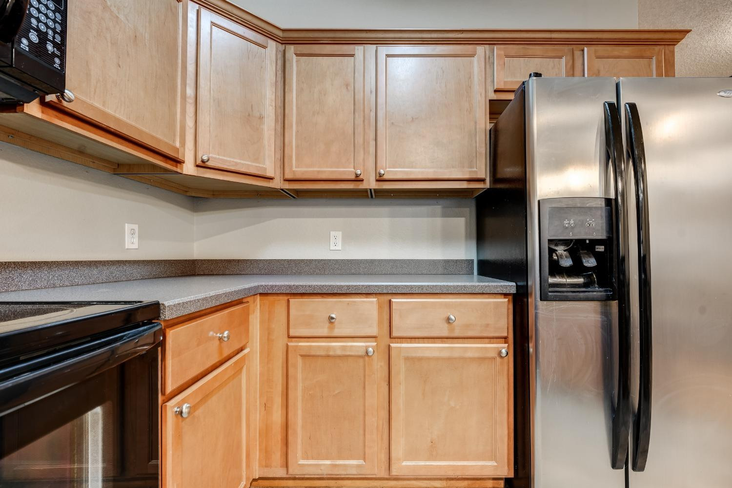 2102 Main Street, Unit 5 Lubbock, TX 79401 - Photo 17 of 27 a kitchen with stainless steel appliances granite countertop a refrigerator and cabinets