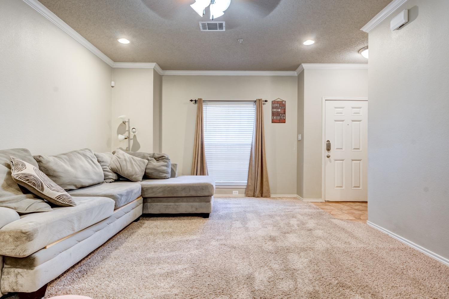 2102 Main Street, Unit 5 Lubbock, TX 79401 - Photo 9 of 27 a living room with furniture and a chandelier