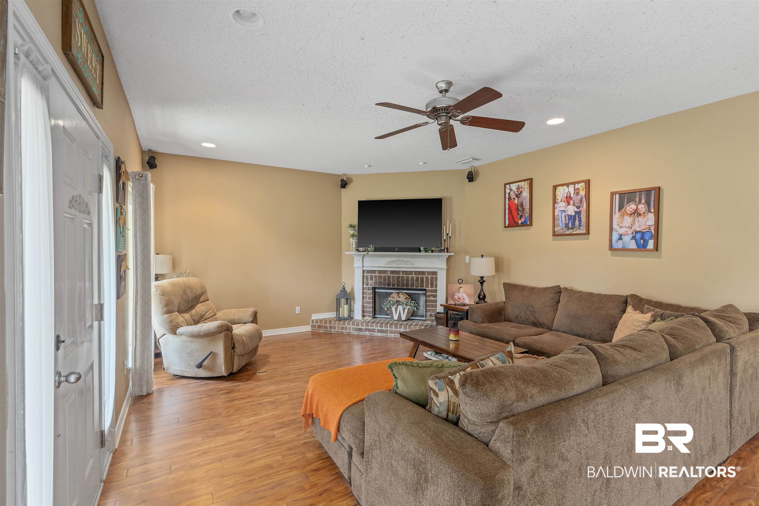 34711 Pond Road Stapleton, AL 36578 - Photo 8 of 38 Living area featuring light wood finished floors, a textured ceiling, a brick fireplace, ceiling fan, and recessed lighting