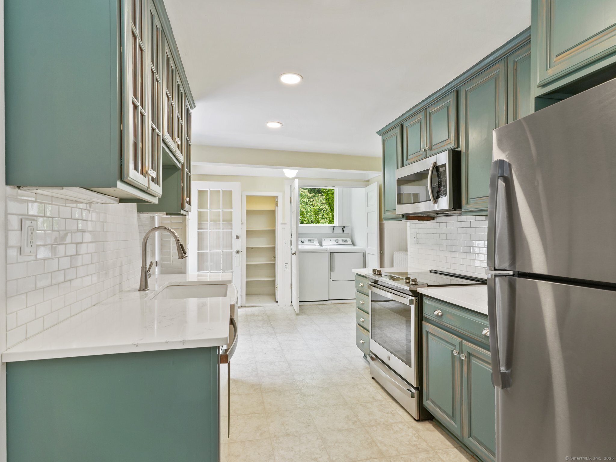 355 Main Street Old Saybrook, CT 06475 - Photo 11 of 29 a kitchen with stainless steel appliances a refrigerator sink and cabinets