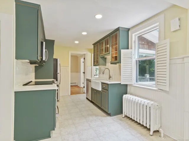 a large kitchen with a window and stainless steel appliances