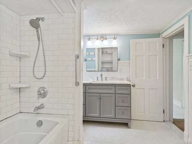 a bathroom with a sink vanity tub and shower