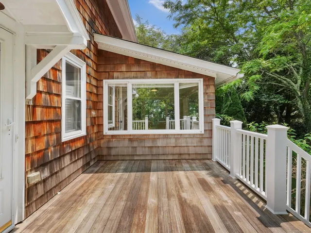 a view of backyard with large trees and wooden fence
