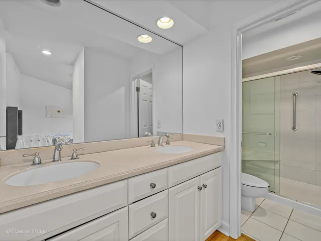 a bathroom with a granite countertop sink a toilet and shower