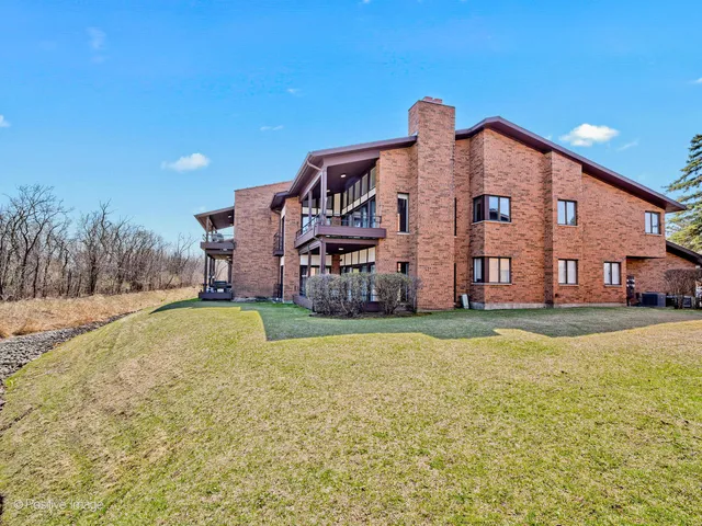 a view of a big house with a big yard and large trees