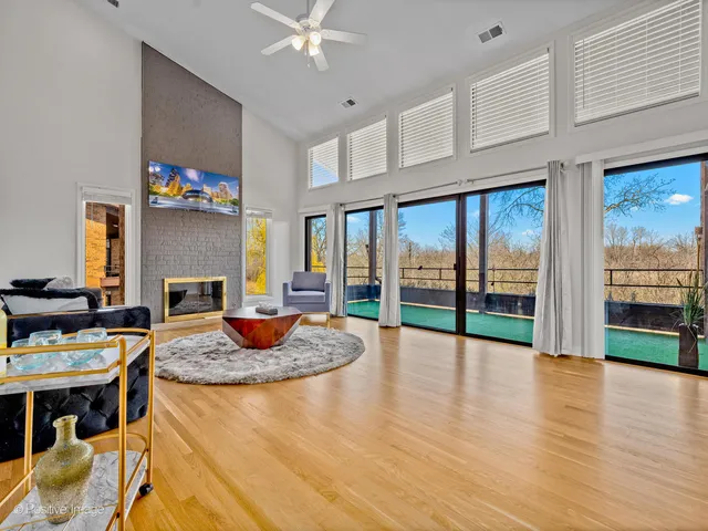 a living room with fireplace furniture and a floor to ceiling window