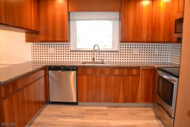 a kitchen with wooden floor door and a window