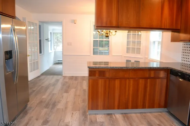 a kitchen with stainless steel appliances wooden floors and wooden cabinets