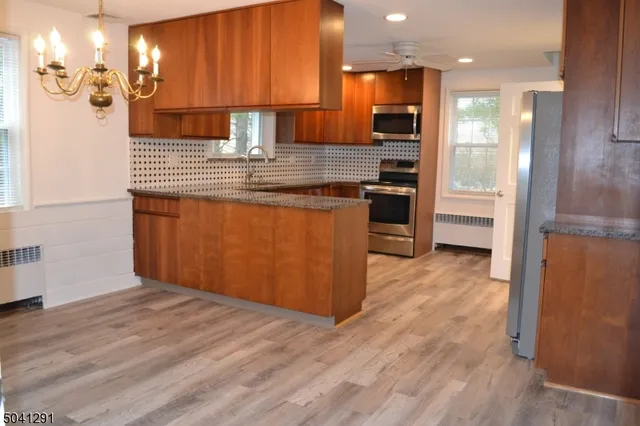 a kitchen with stainless steel appliances granite countertop a refrigerator and a stove top oven
