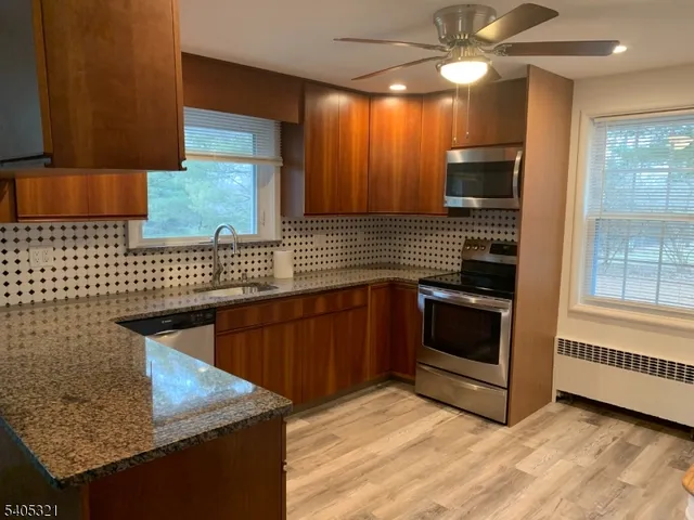 a kitchen with stainless steel appliances granite countertop a sink and a stove