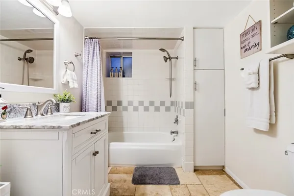 a bathroom with a granite countertop sink a bathtub and a mirror