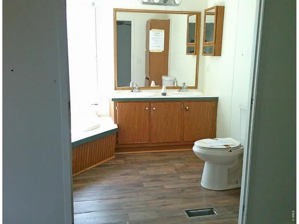 a bathroom with a toilet a sink and mirror