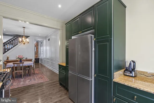a kitchen with a refrigerator and table chairs