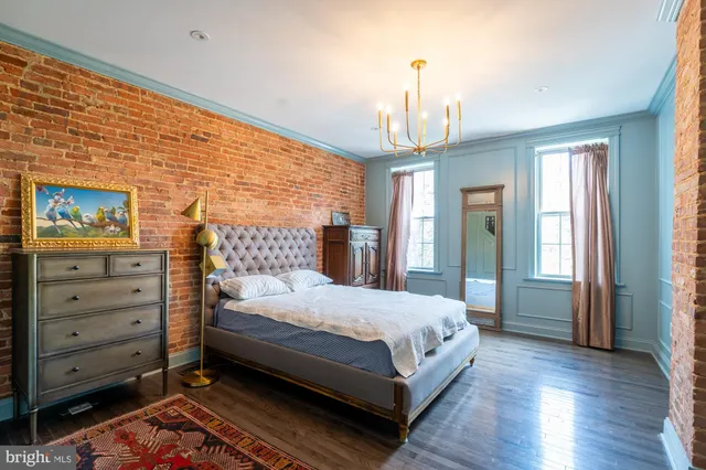 a bedroom with a large bed and a chandelier