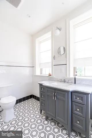 a bathroom with a sink a toilet and a window