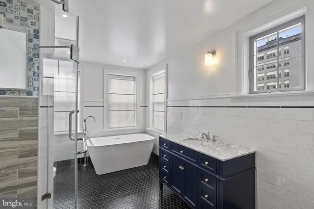 a bathroom with a bathtub and next to a window