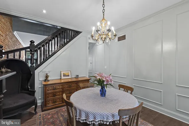 a dining room with furniture a chandelier and wooden floor