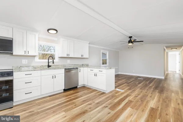 a view of empty room with wooden floor and ceiling fan