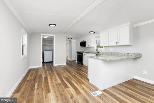 a kitchen with granite countertop a stove a sink and a microwave