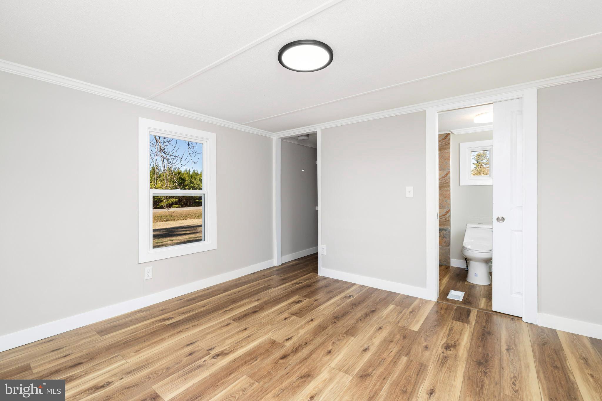 870 South Hill Road Brodnax, VA 23920 - Photo 29 of 39 a view of an empty room with wooden floor and window