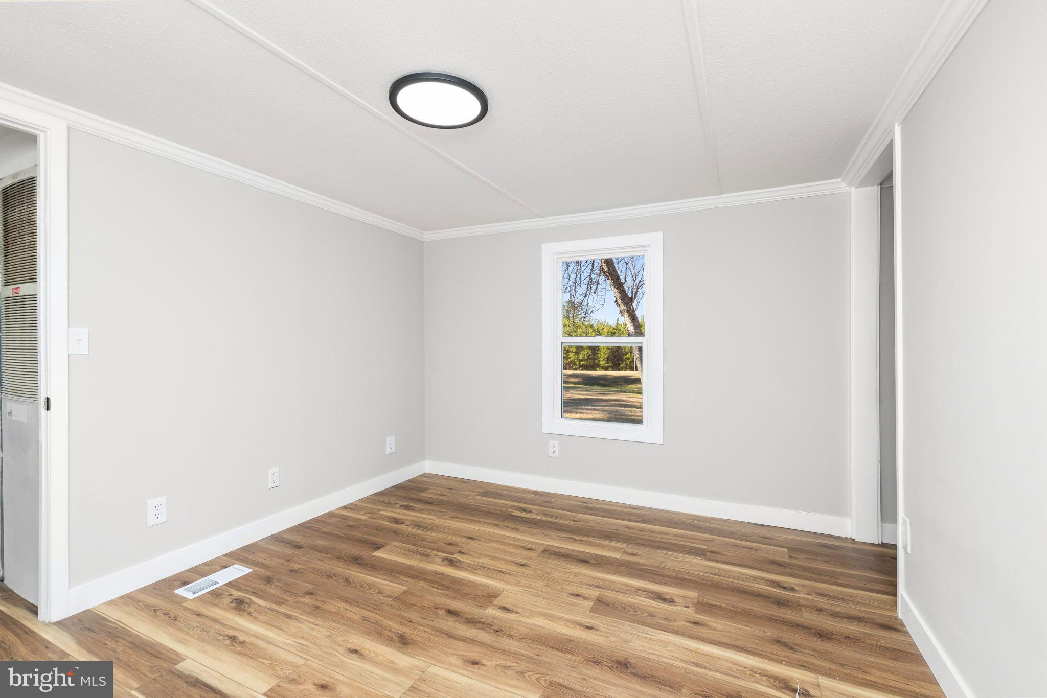 870 South Hill Road Brodnax, VA 23920 - Photo 32 of 39 a view of an empty room with wooden floor and a window