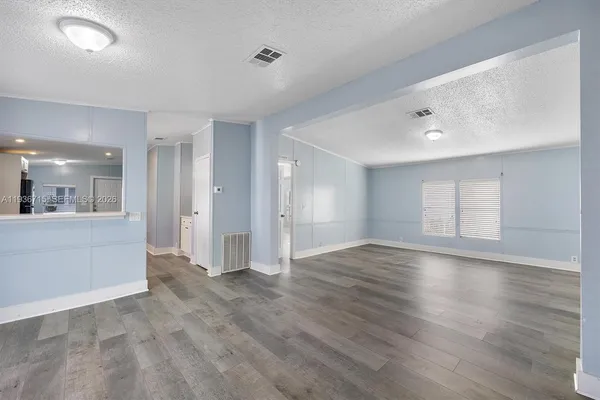 a view of an empty room and wooden floor