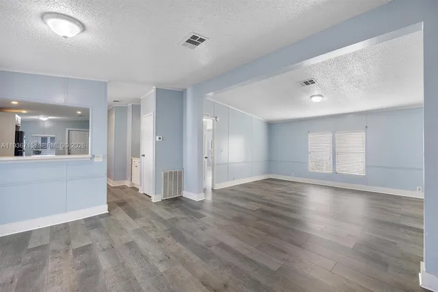 a view of an empty room and wooden floor
