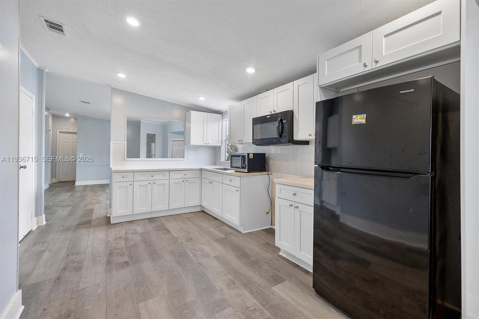 19800 Southwest 180th Avenue Miami, FL 33187 - Photo 22 of 36 a kitchen with white cabinets and stainless steel appliances