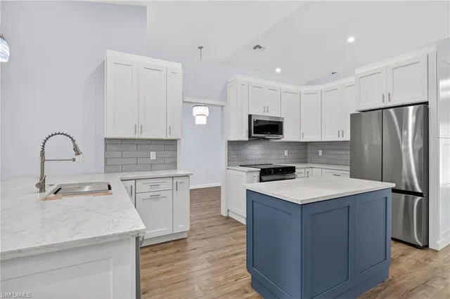 a kitchen with stainless steel appliances a refrigerator sink and cabinets