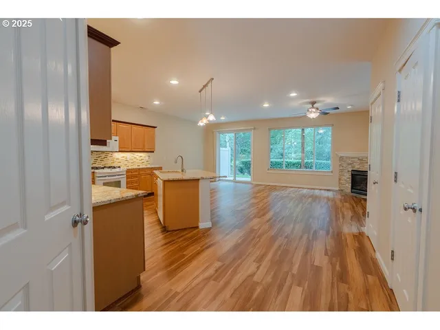 a open kitchen with cabinets stainless steel appliances and a wooden floor