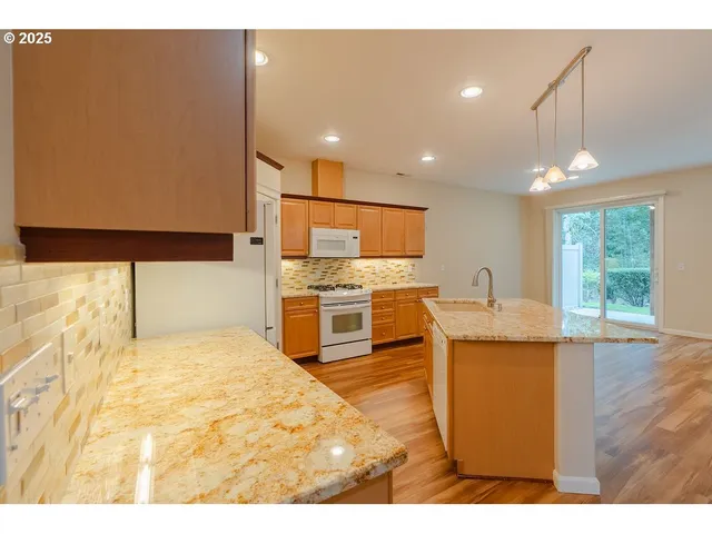a kitchen with stainless steel appliances kitchen island granite countertop a sink and cabinets