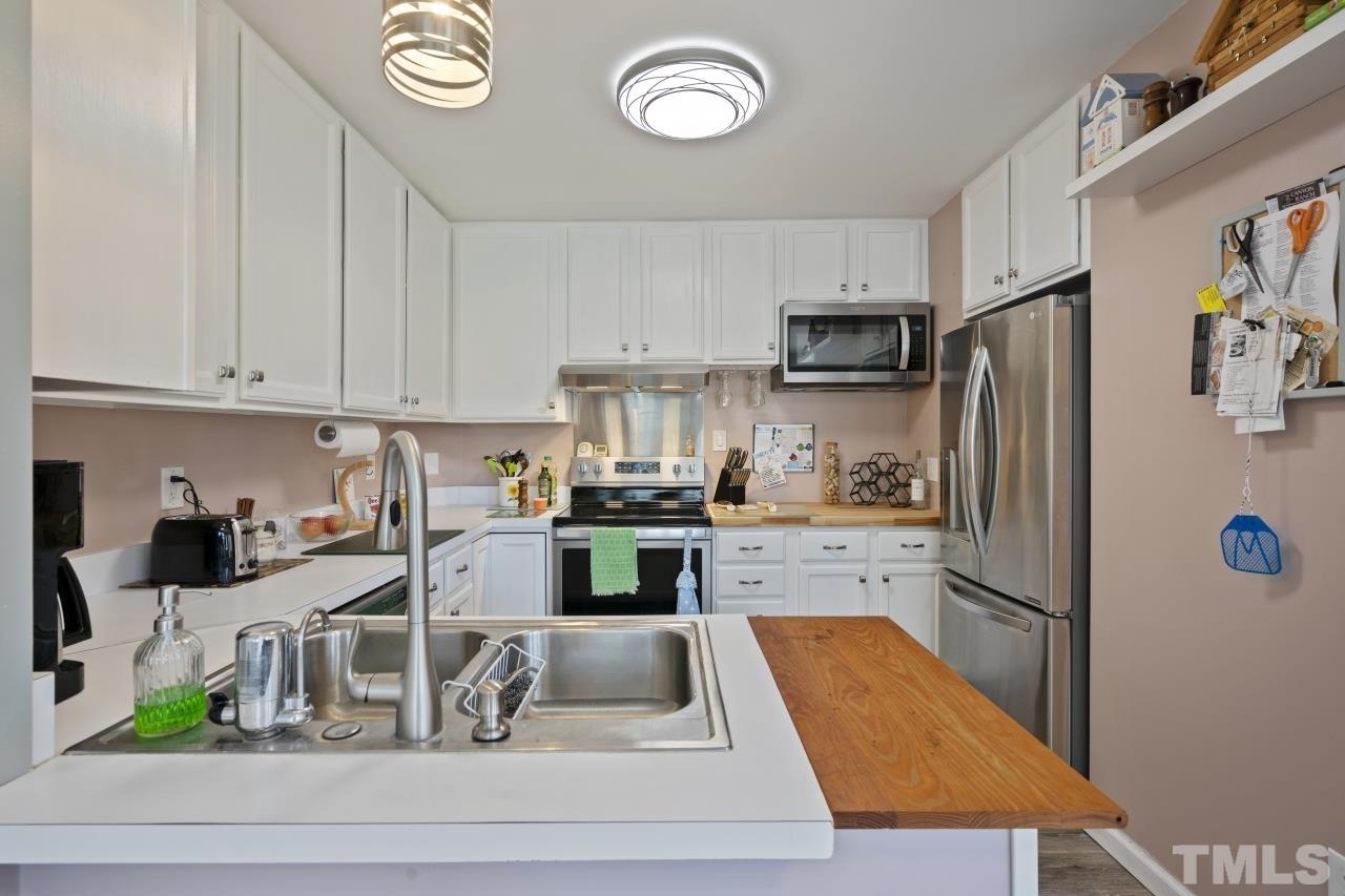 7020 Max Lane Raleigh, NC 27603 - Photo 4 of 16 a kitchen with stainless steel appliances granite countertop a refrigerator sink and stove
