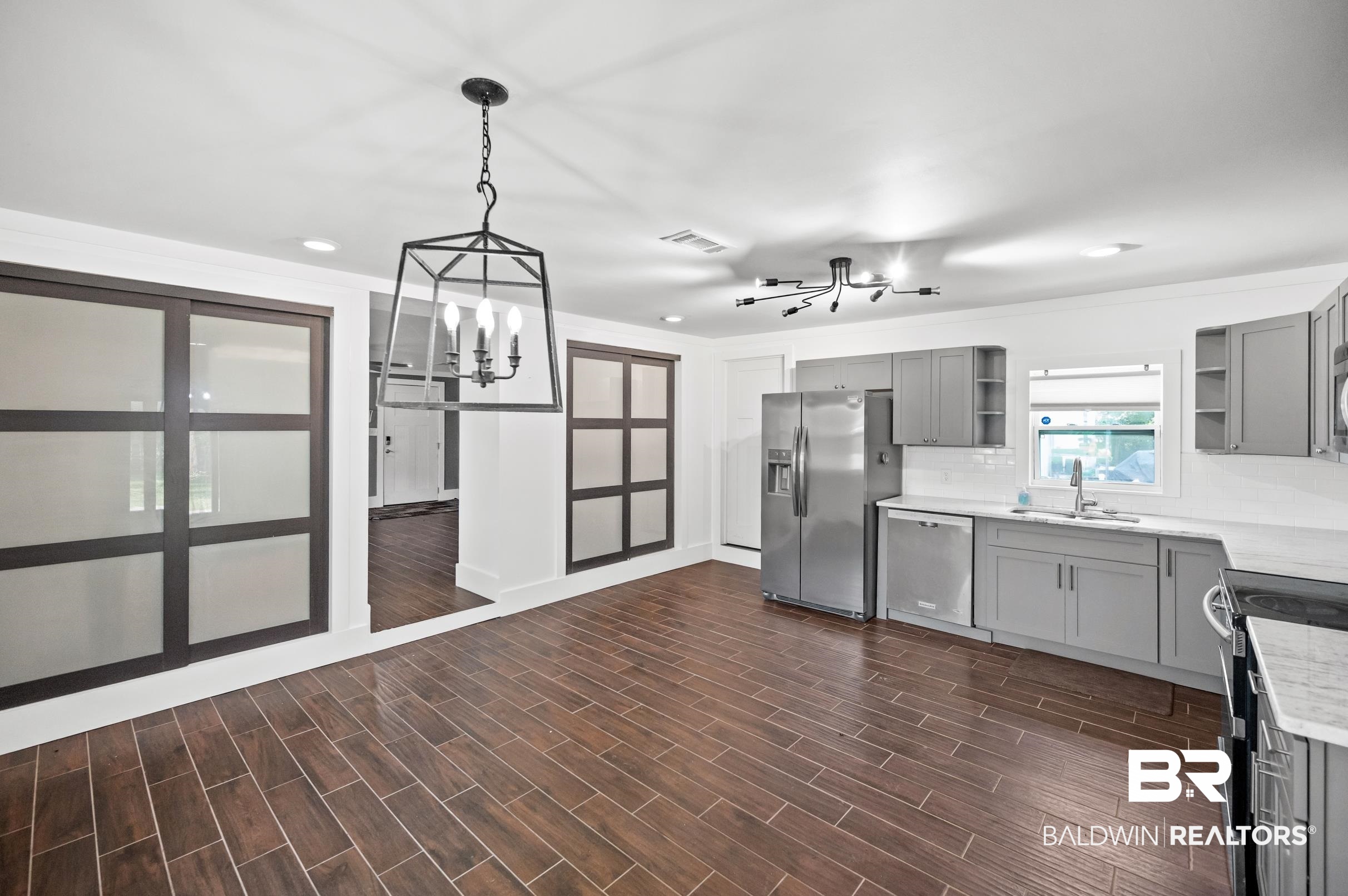 24663 Chestnut Street Elberta, AL 36530 - Photo 7 of 22 Modern kitchen featuring stainless steel appliances, grey cabinetry, white countertops, and a subway tile backsplash