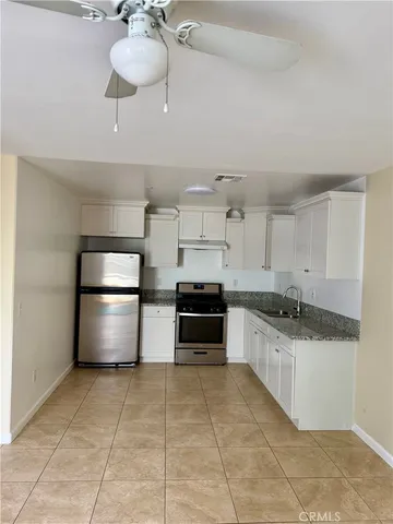 a kitchen with a stove a refrigerator and a sink