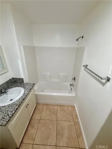 a bathroom with a granite countertop sink a toilet and bathtub