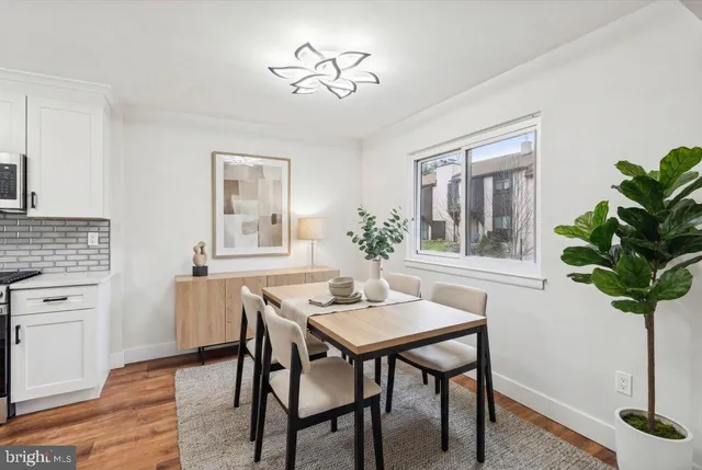 a dining room with furniture potted plants and wooden floor