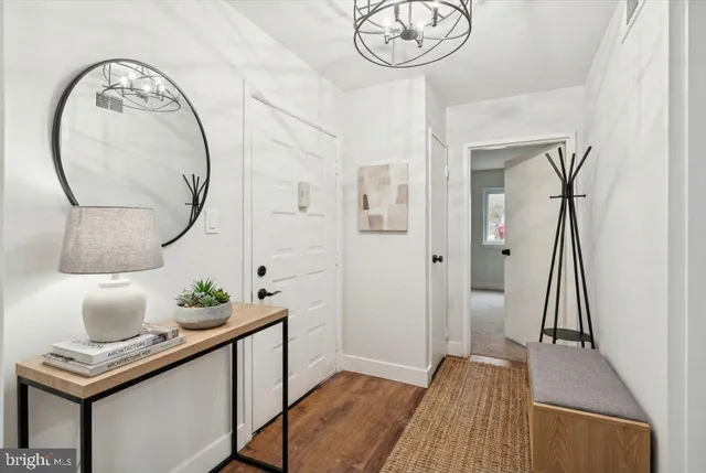 a view of hall way with furniture and a mirror