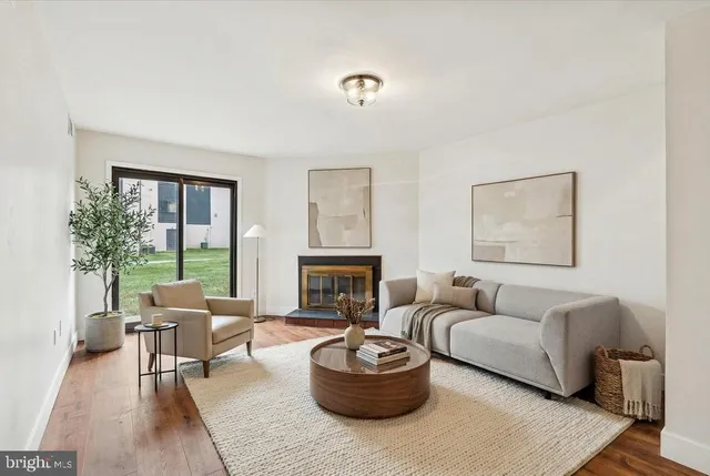 a living room with furniture a fireplace and a large window