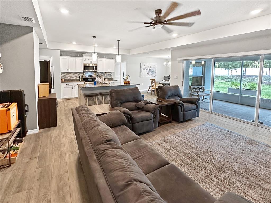 13023 Downy Woodpecker Road Weeki Wachee, FL 34614 - Photo 13 of 43 a living room with furniture kitchen view and a large window
