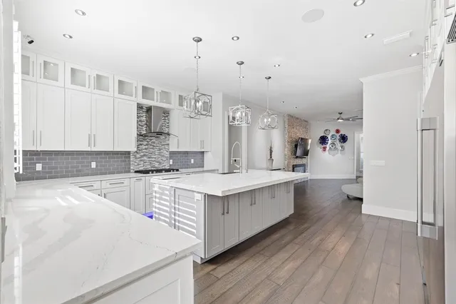 a large kitchen with a lot of counter space and wooden floor