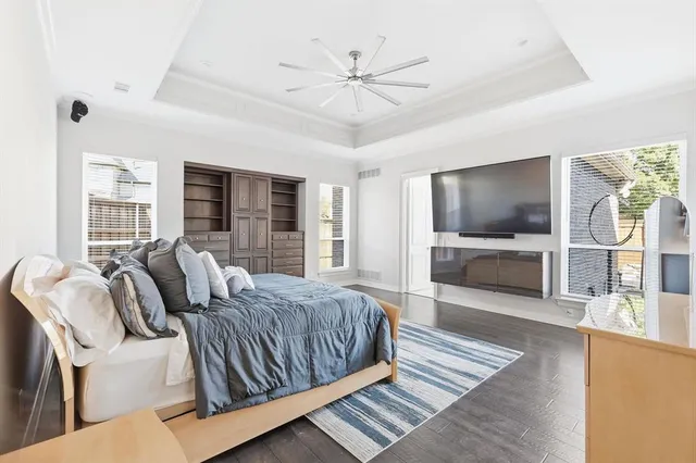 a bedroom with a large bed a flat tv screen and balcony