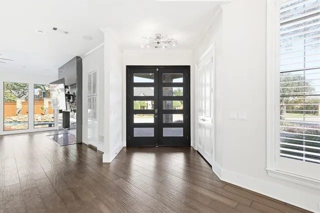 a view of a hallway with wooden floor and a window