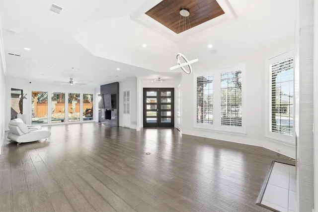 a view of an empty room with wooden floor and a large window