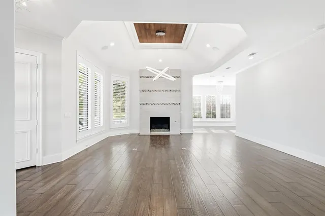 a view of a livingroom with wooden floor and a fireplace