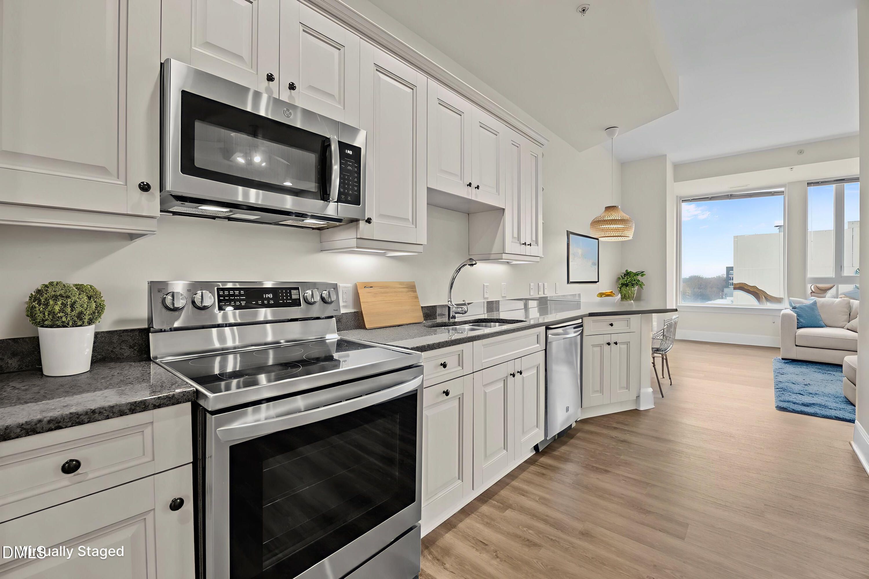 400 West North Street, Unit 814 Raleigh, NC 27603 - Photo 14 of 41 a kitchen with stainless steel appliances granite countertop a stove a sink dishwasher and a microwave oven with wooden floor
