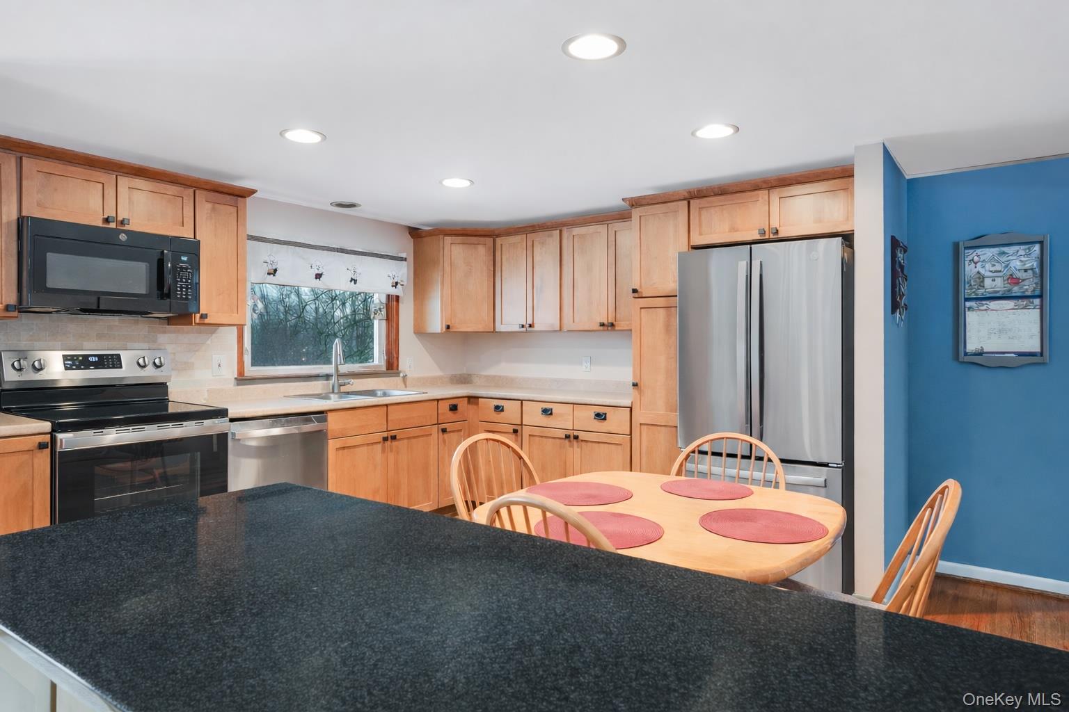33 Milltown Road Brewster, NY 10509 - Photo 9 of 30 a kitchen with stainless steel appliances granite countertop a refrigerator a stove top oven a sink dishwasher a dining table and chairs with wooden floor