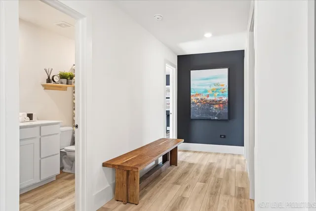 a view of a hallway and a room with wooden floor