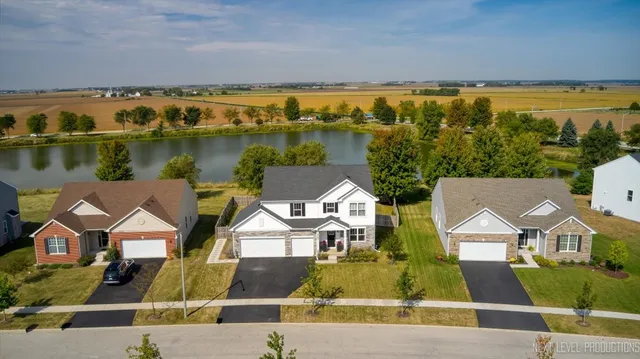 an aerial view of residential houses with outdoor space and ocean view