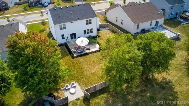 an aerial view of a house with a swimming pool a yard and a garage