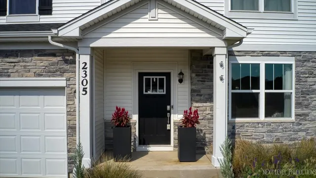 a front view of a house with a potted plant